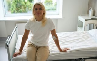 Patient sits on a hospital bed in a bright room
