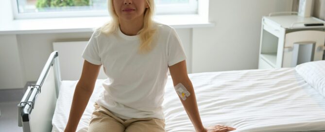 Patient sits on a hospital bed in a bright room